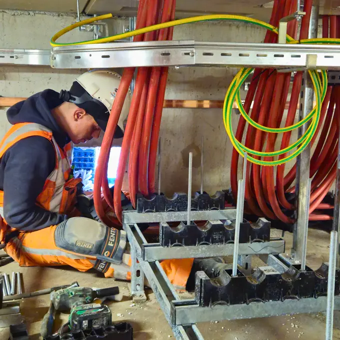 Monteur Thomas bezig met kortsluitvast in blokken gelijkspanningskabels